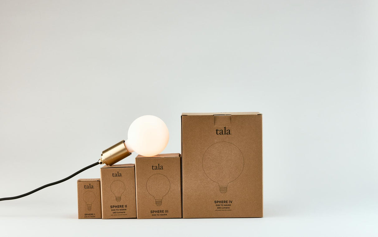 Tala dim to warm LED light bulbs in four sizes with minimalist brown packaging and illuminated bulb