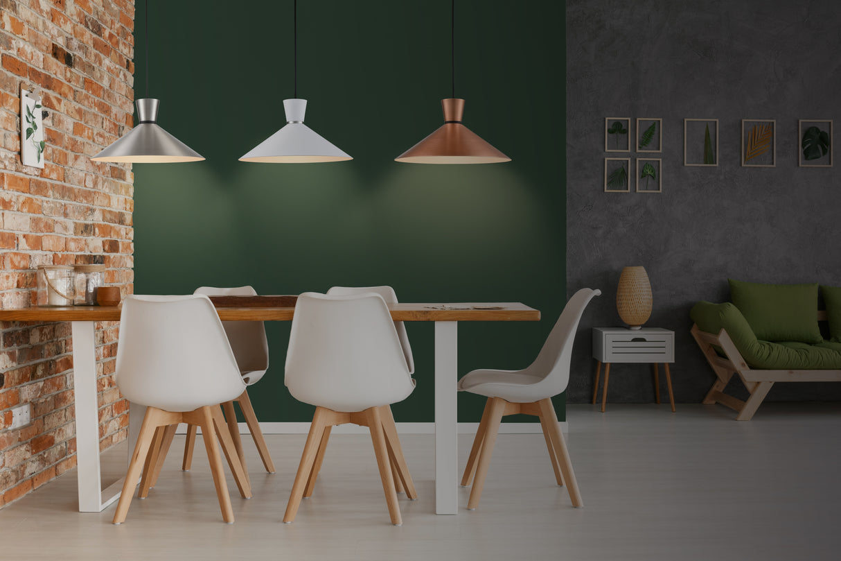 Modern dining area with wooden table, white chairs, pendant lamps, green accent wall and brick wall