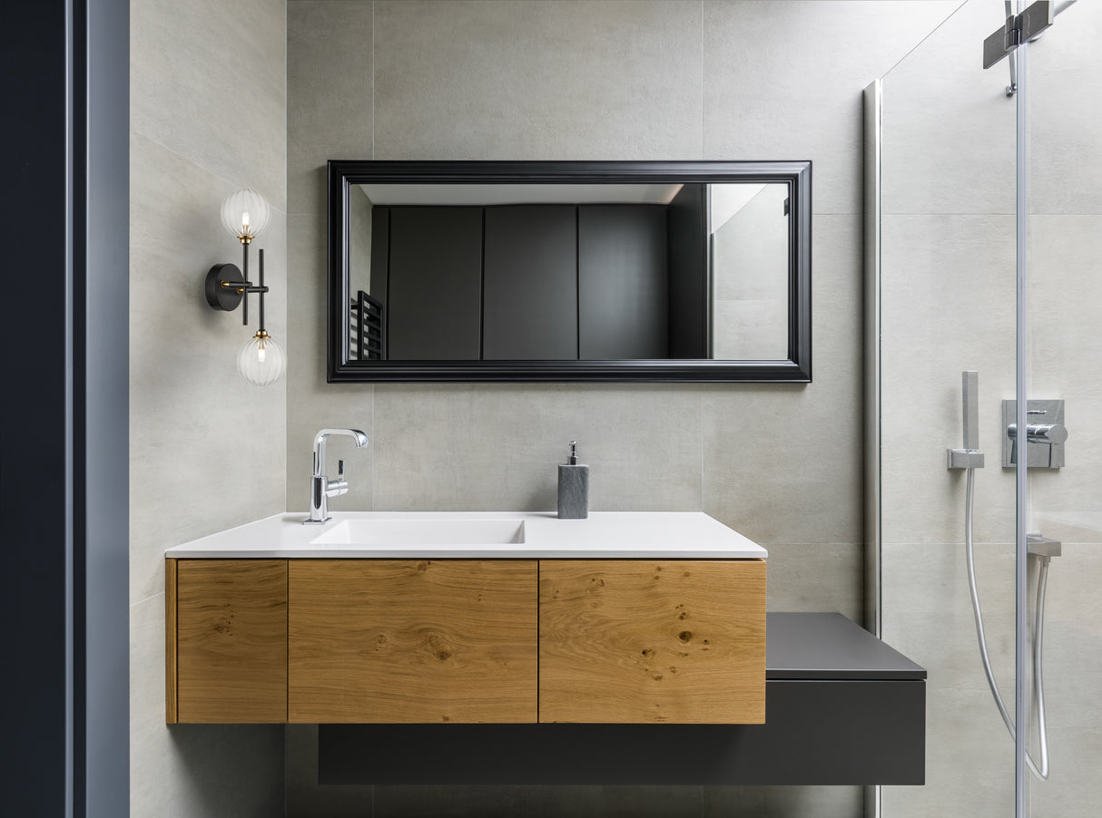 Modern bathroom with floating wooden vanity, white sink, black framed mirror, and glass shower