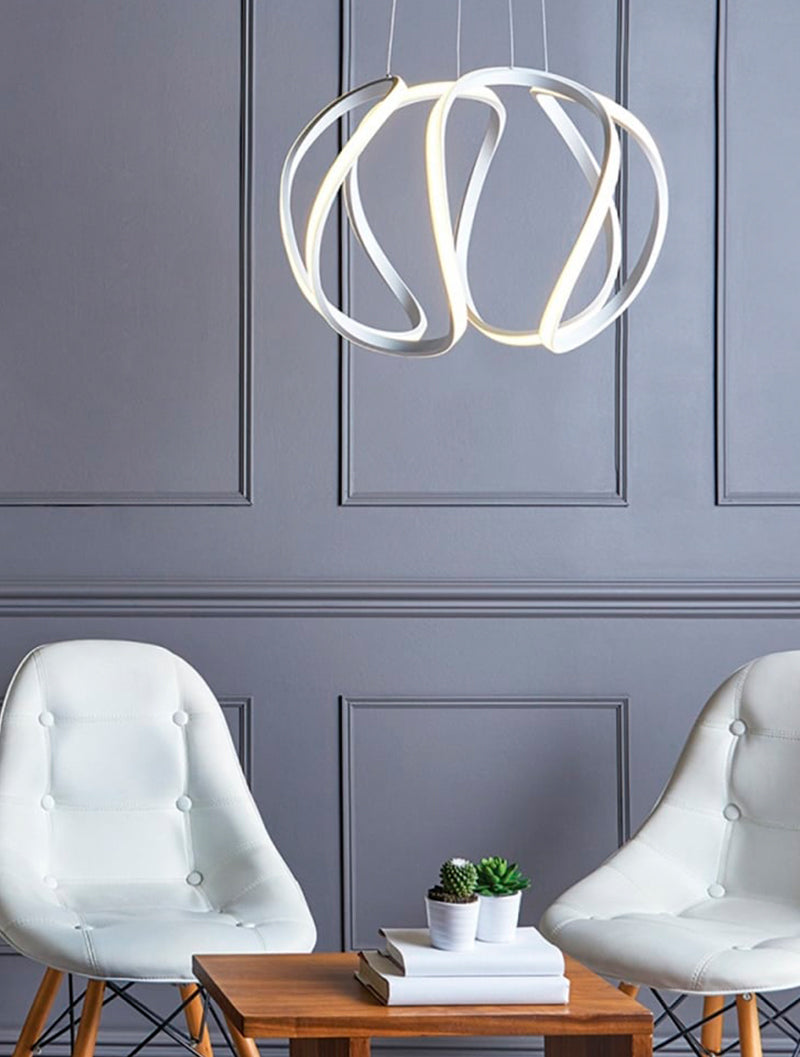 Modern white LED pendant light above wooden table with books and succulents, flanked by two white chairs