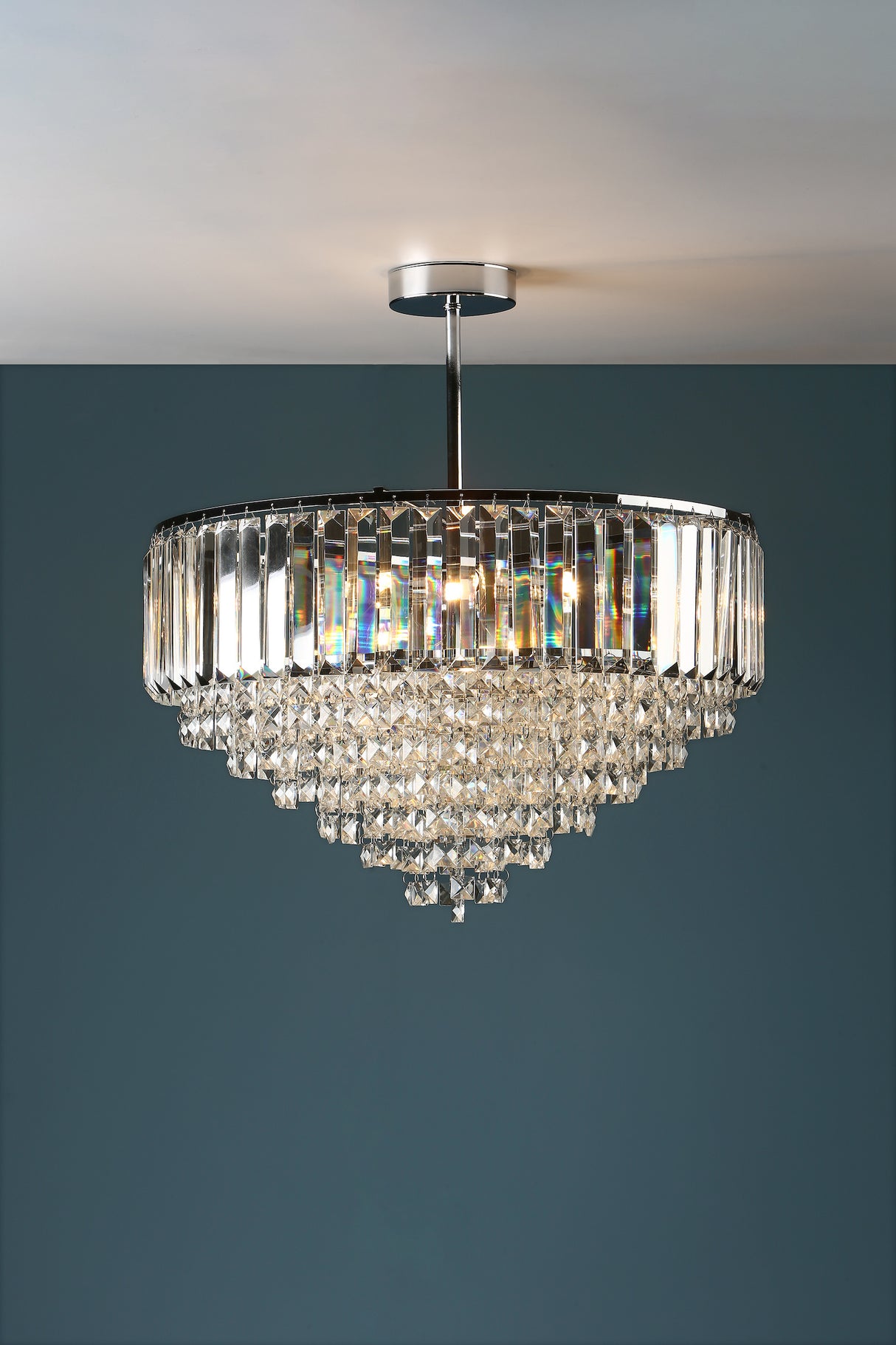 A Laura Ashley Vienna 5 Light Semi Flush Crystal and Polished Chrome ceiling light fixture against a dark background, showcasing its glittering fountain of square-cut faceted glass droplets and polished chrome finish.