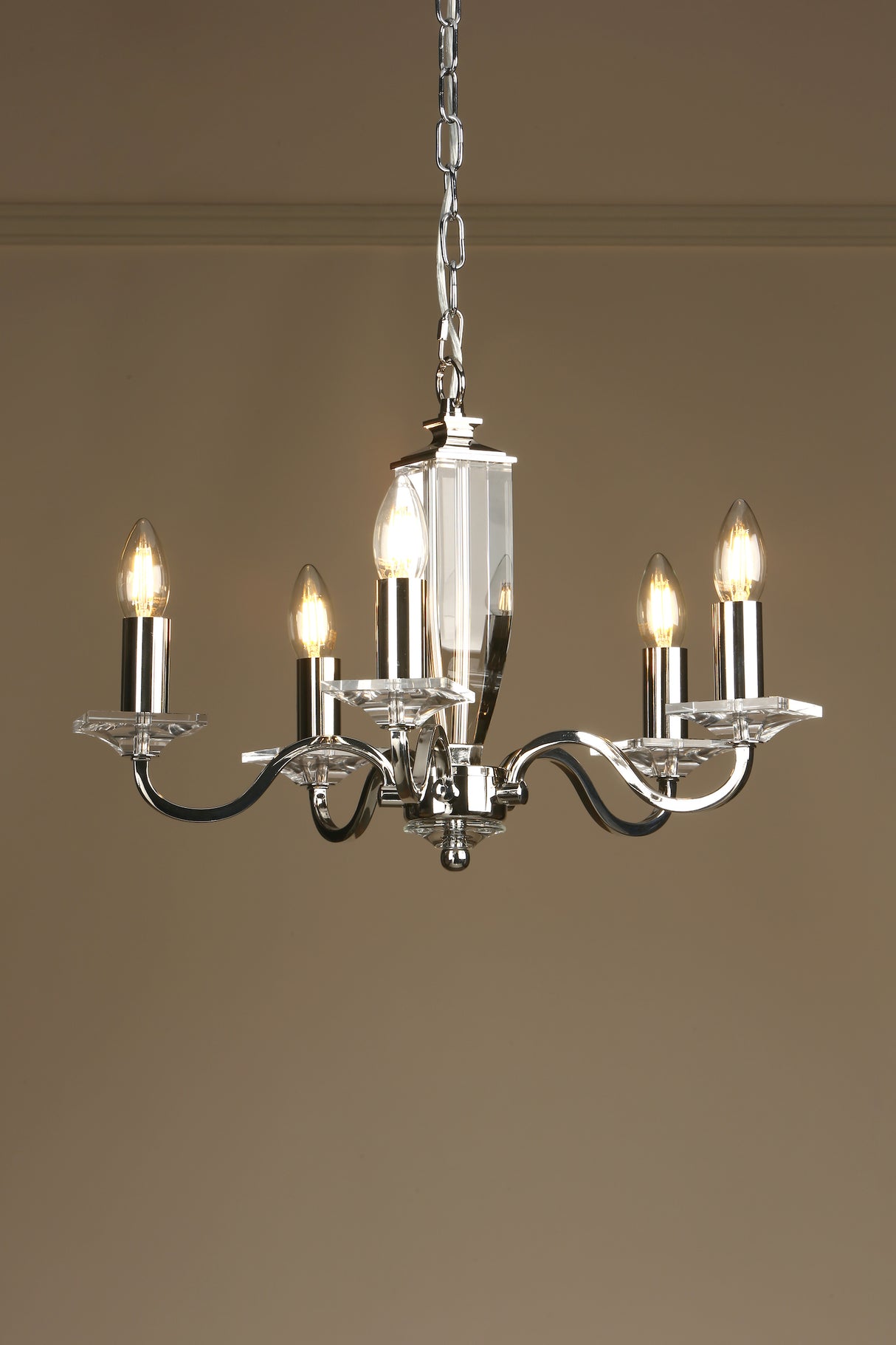 Modern six-light chrome chandelier with candle-style bulbs hanging from chain