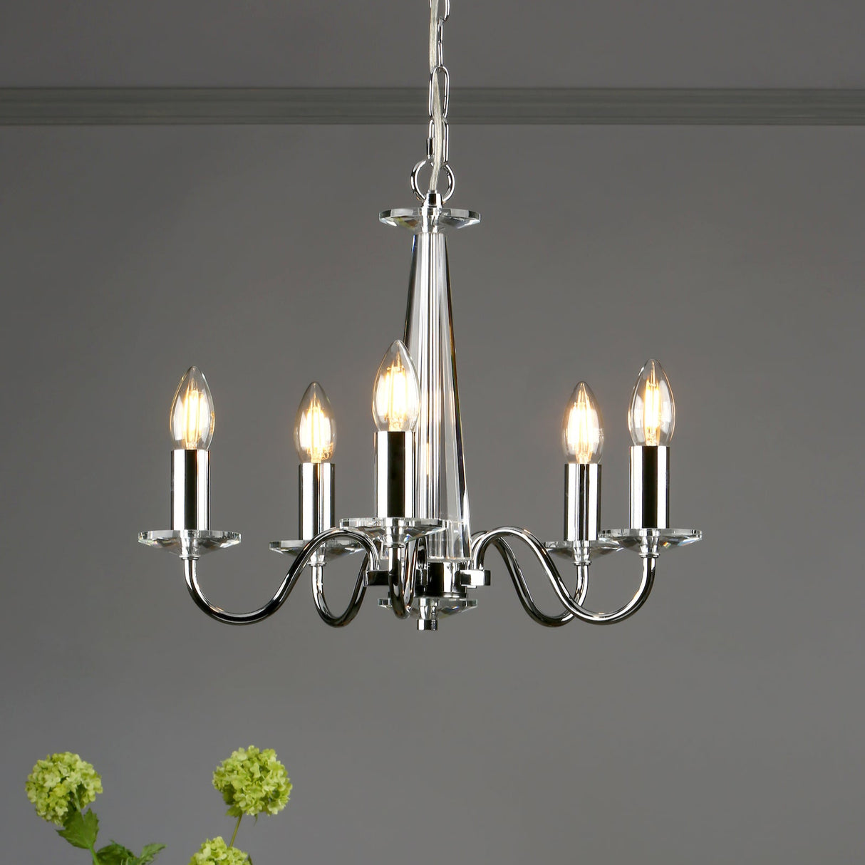 Modern chrome chandelier with five candle-style LED bulbs hanging from ceiling