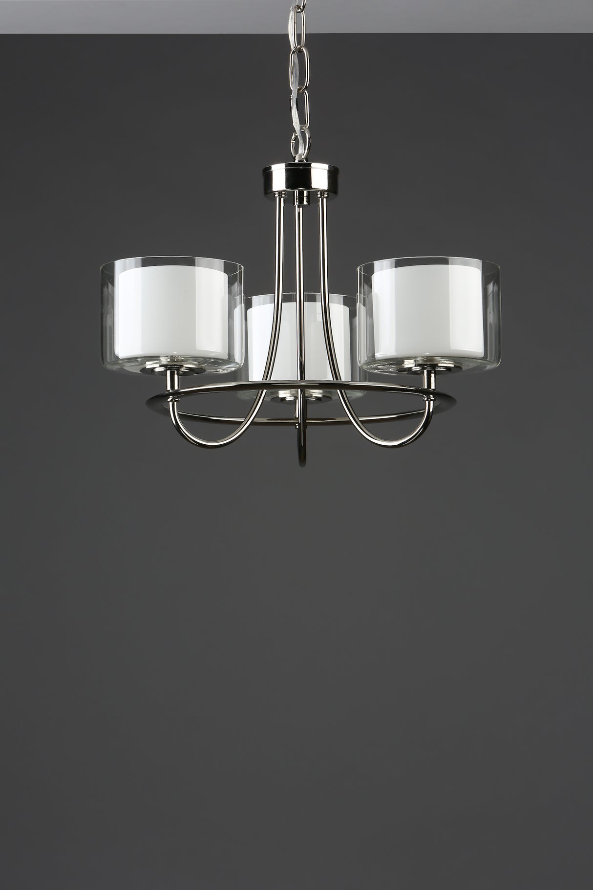 Modern three-light chrome chandelier with white cylindrical glass shades on gray background