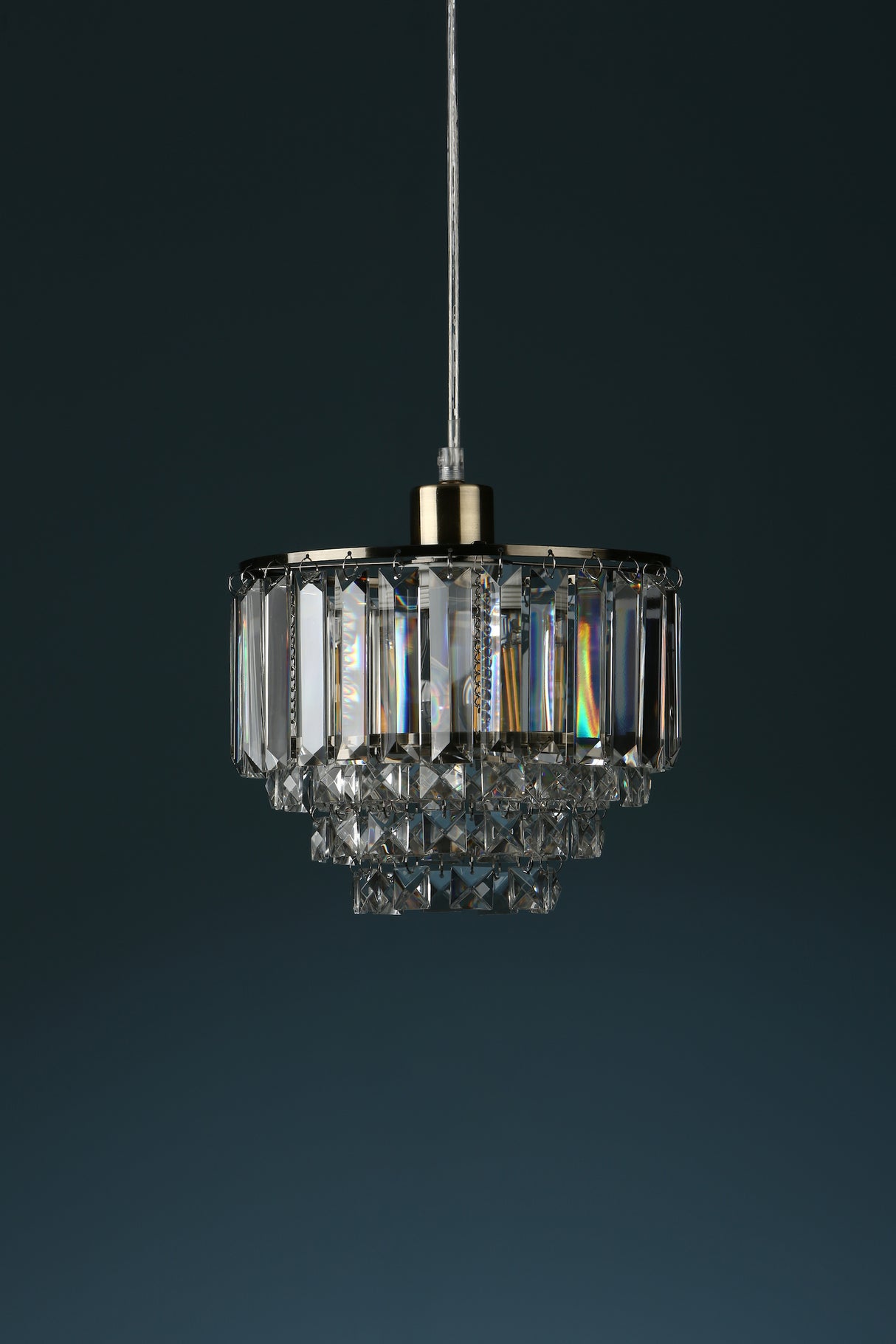 Elegant crystal chandelier pendant light with gold metal accents against dark background