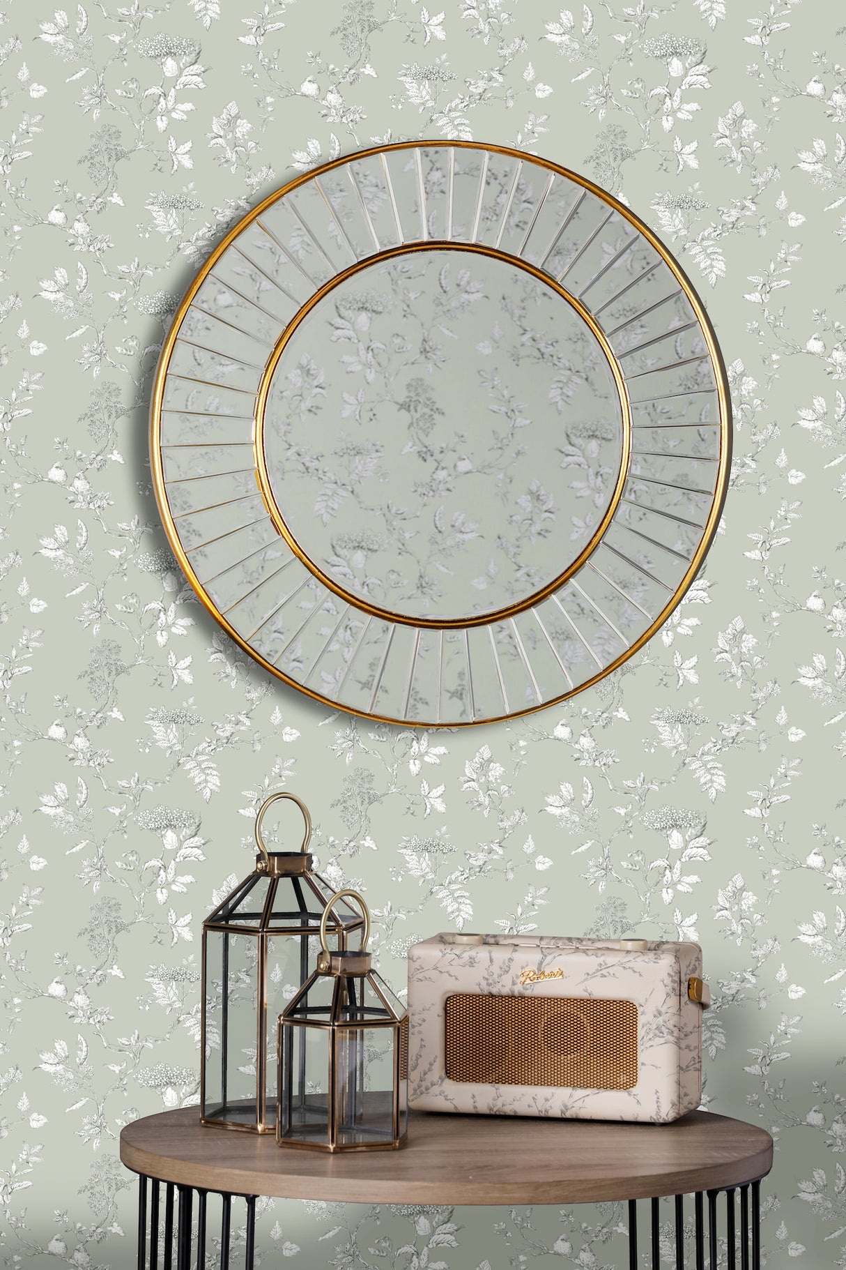 Round gold-framed mirror above wooden table with decorative lanterns and vintage radio
