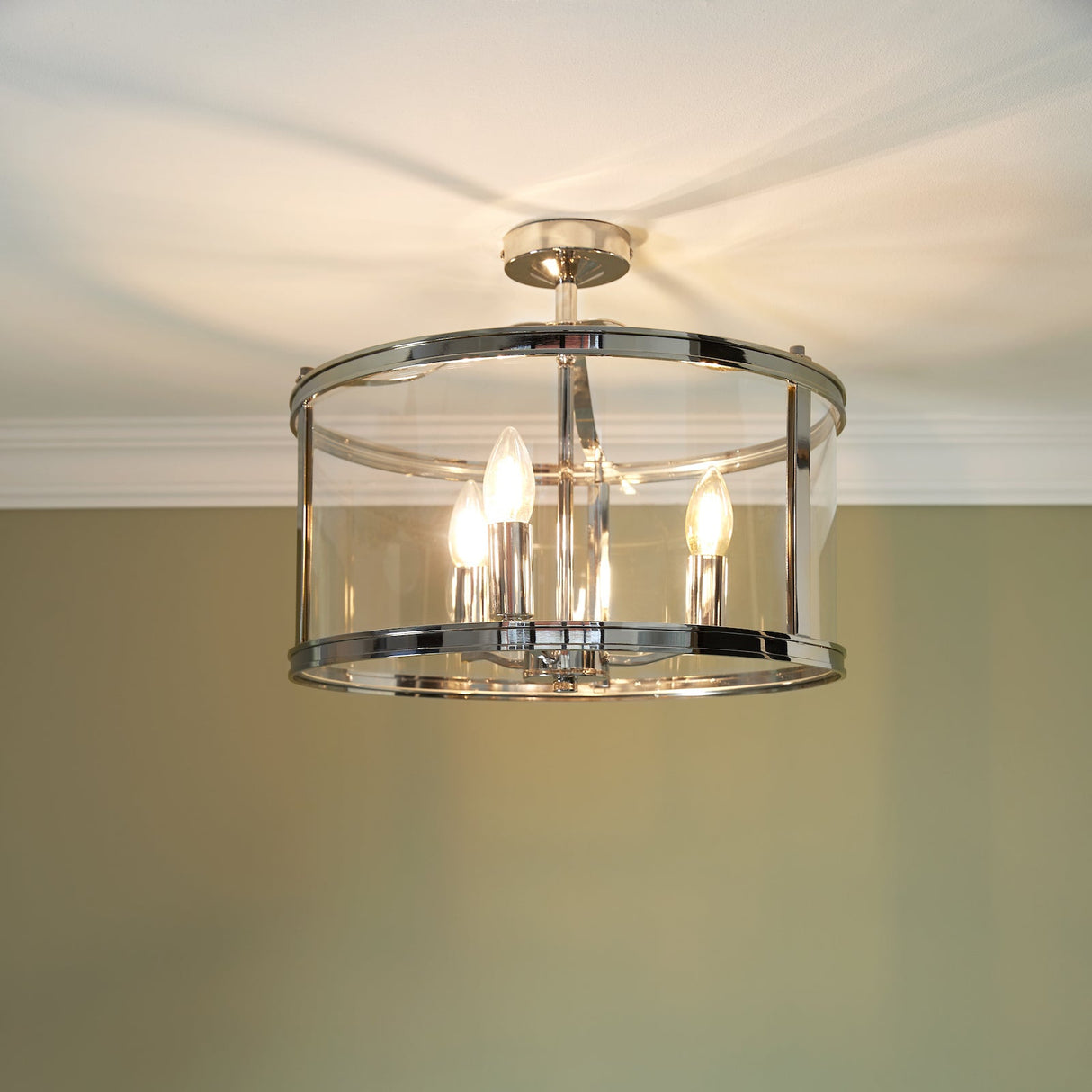 Modern semi-flush ceiling light fixture with three candle bulbs and clear glass shade
