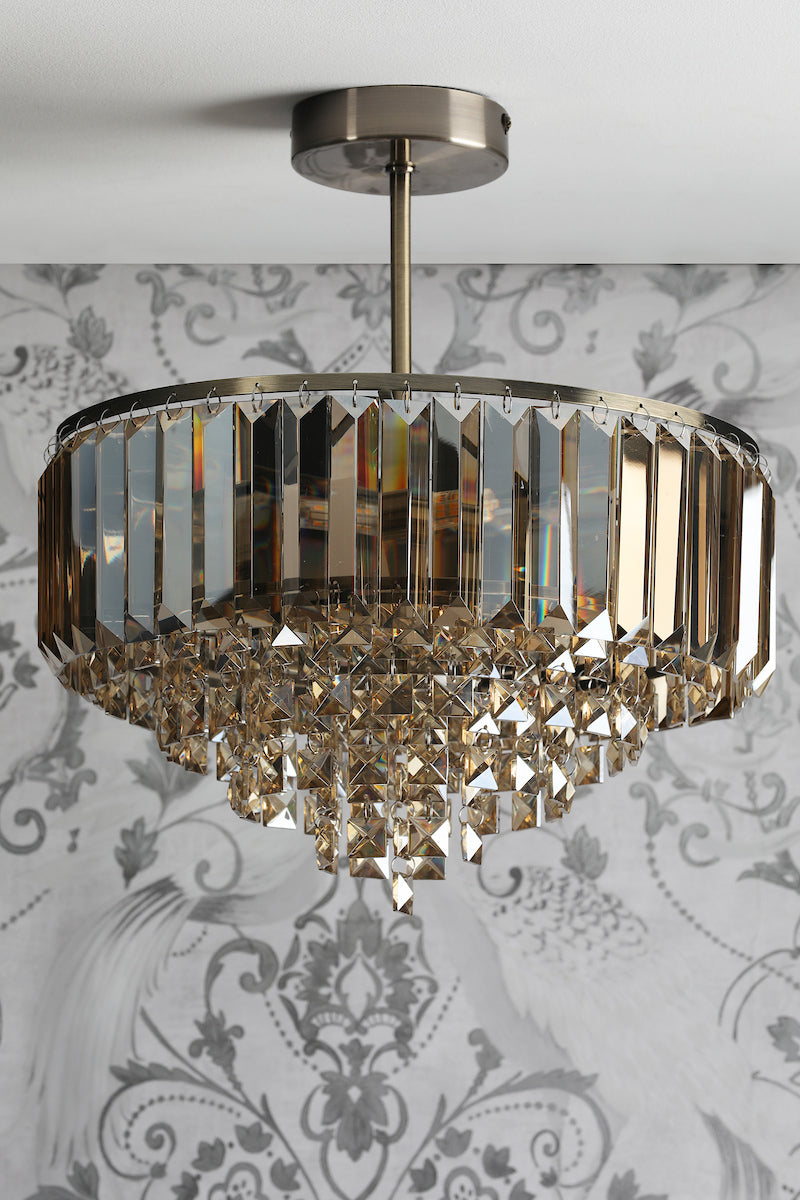 Modern crystal chandelier with brass frame and geometric prism crystals hanging from ceiling