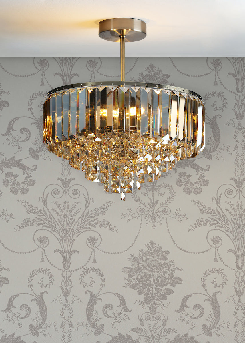 modern crystal chandelier with gold accents mounted on ceiling against patterned wallpaper