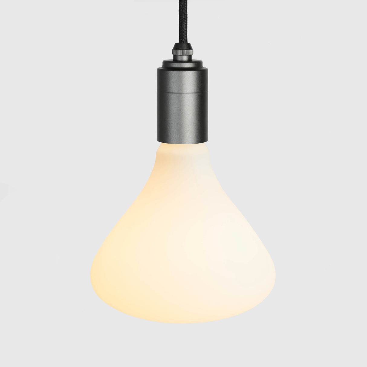 Modern pendant light with warm glowing frosted glass shade and graphite metal fixture
