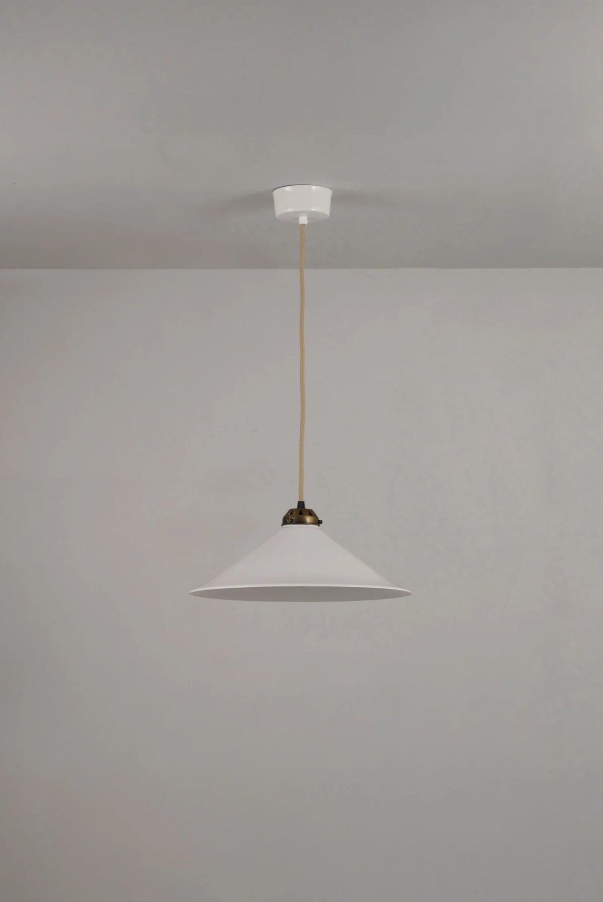 Pendant light with white shade and gold fixture on a gray background