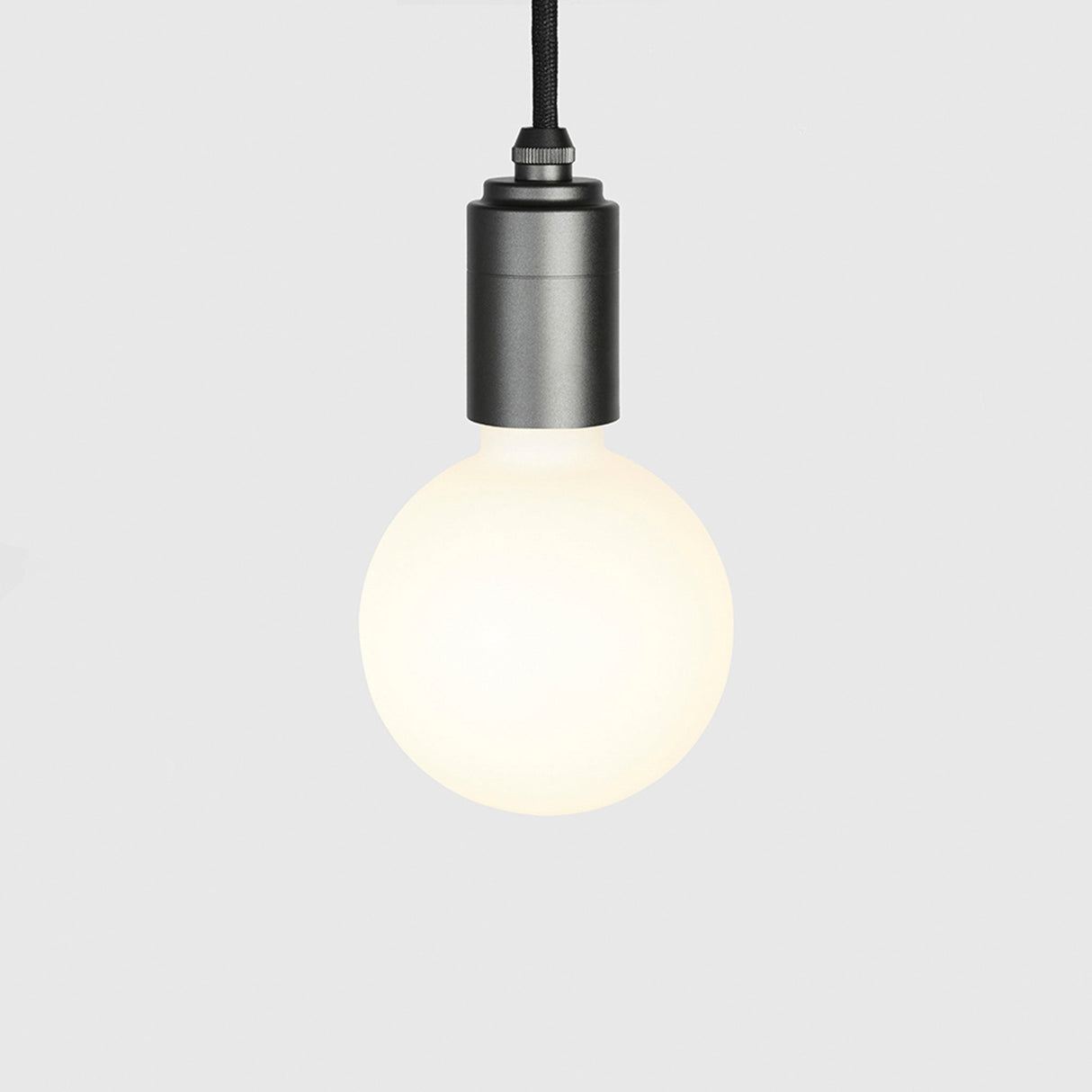 Modern graphite pendant light with round frosted white bulb on gray background