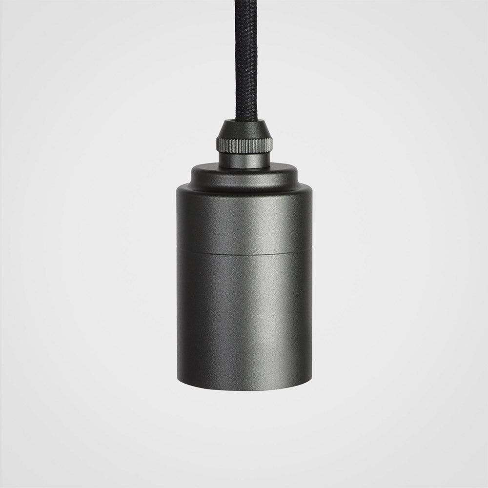 Graphite metal single pendant light with black braided cord on gray background
