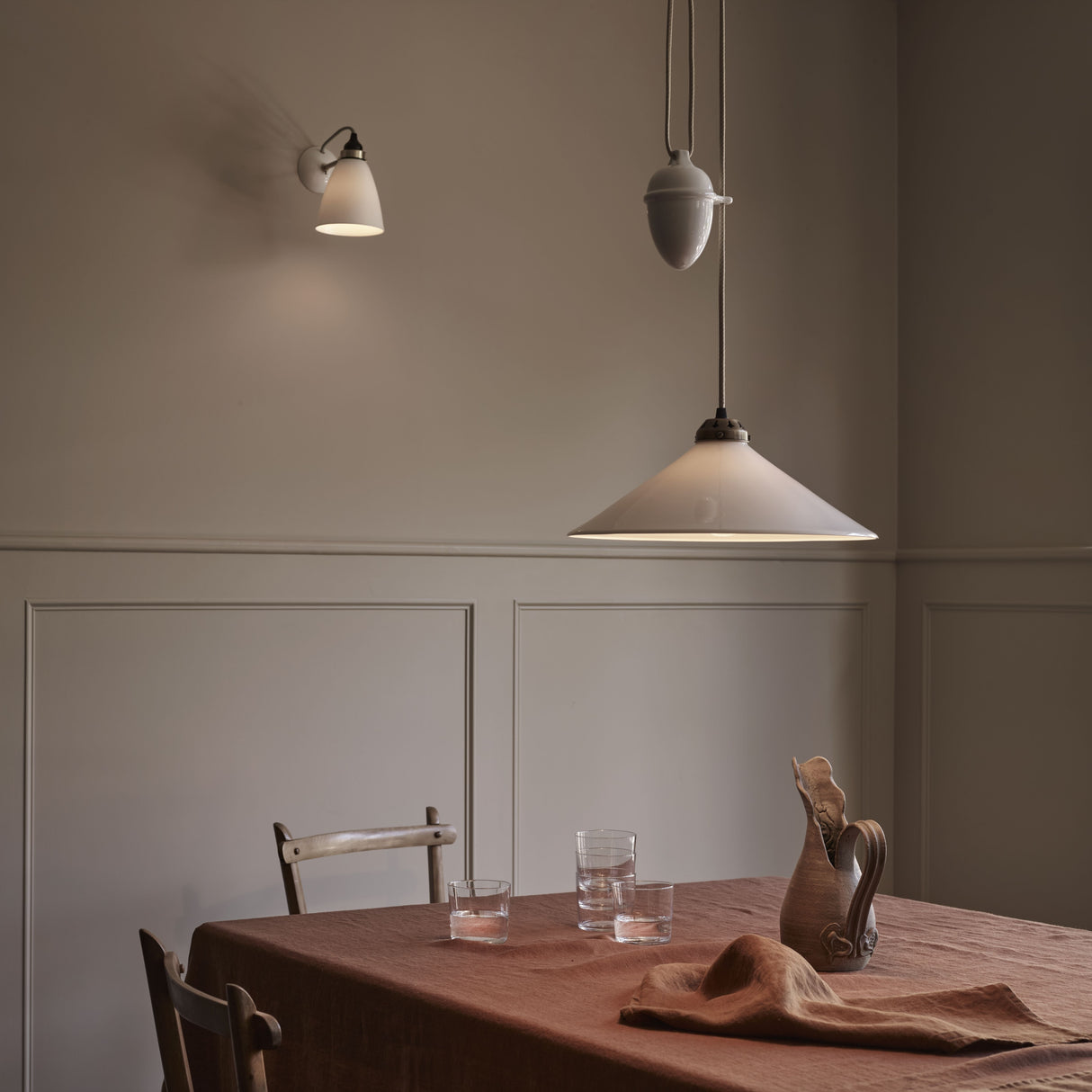 Dining area with a table, chairs, and a pendant light fixture in a dimly lit room.