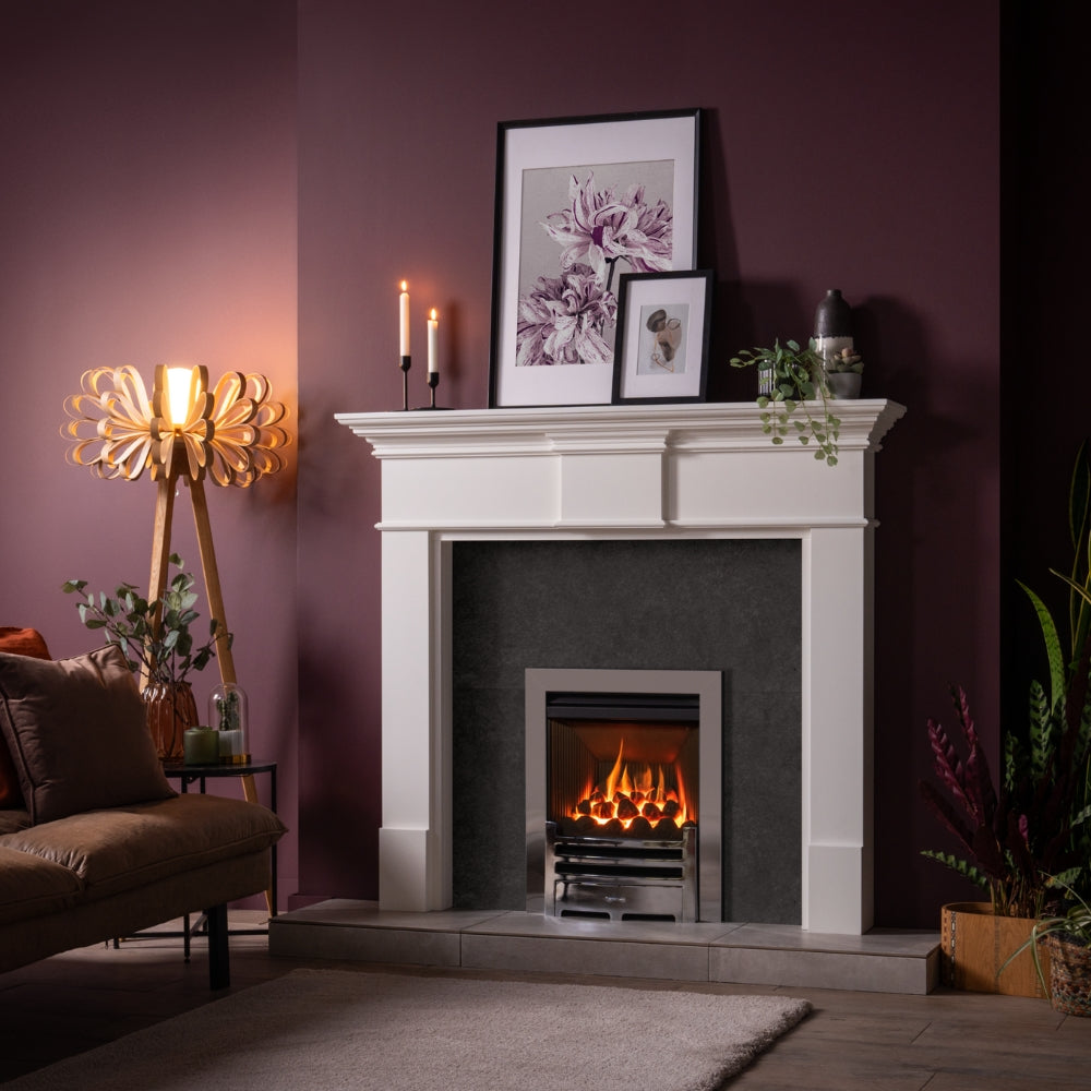 Modern living room with lit fireplace, white mantel, purple wall, wooden loopie floor lamp, and cozy sofa