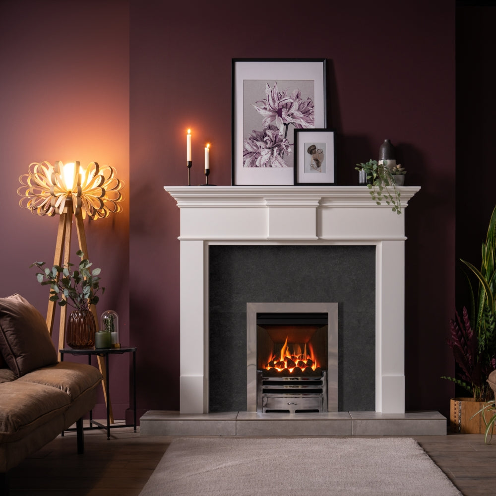 modern living room with white fireplace, lit fire, wooden loopie floor lamp, candles, plant, and artwork