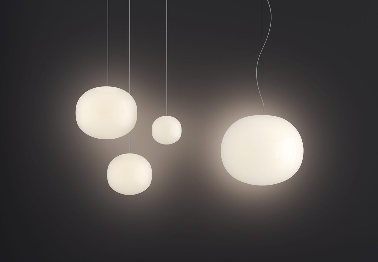 Modern white glass pendant lights with soft glowing light against dark background