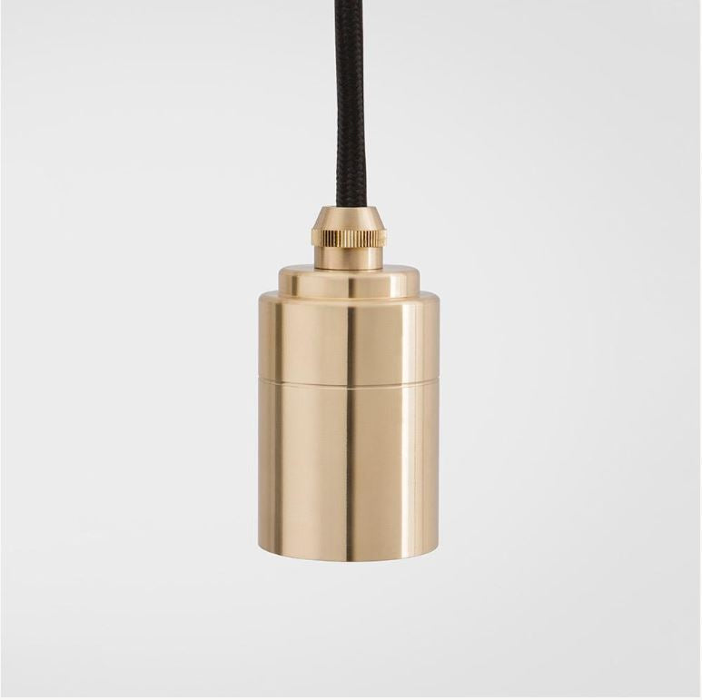 Tala single turned brass pendant light with black cord on plain white background