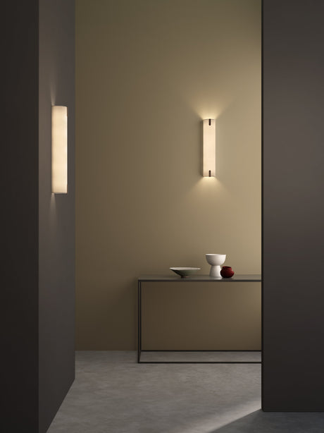 Minimalist interior with beige wall, modern wall sconces, and sleek console table with decorative bowls