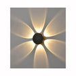 Modern wall light fixture projecting warm yellow petal-shaped light patterns on gray wall