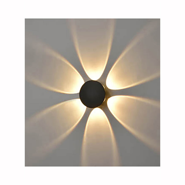 Modern wall light fixture projecting warm yellow petal-shaped light patterns on gray wall