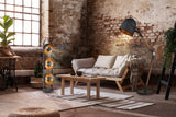 Industrial loft living room with wooden sofa, floor lamps, plants, and exposed brick walls