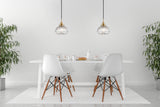 Minimalist white dining table set with croissants, eggs, and pendant lights in bright room