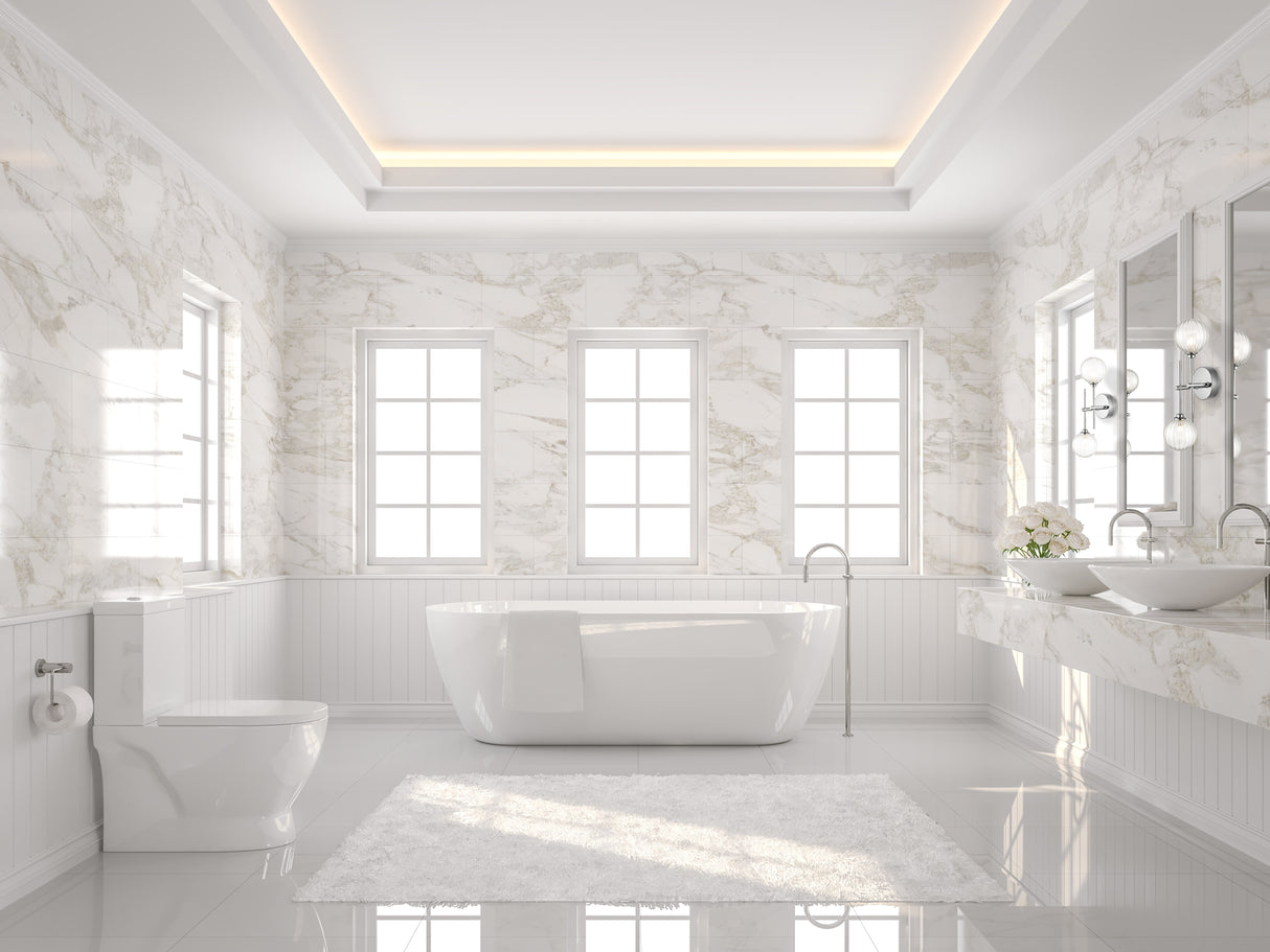 Bright modern bathroom with freestanding white tub, marble walls, double sinks, and fluffy rug