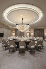 Luxury dining room with round marble table, beige chairs, crystal chandelier, and elegant decor