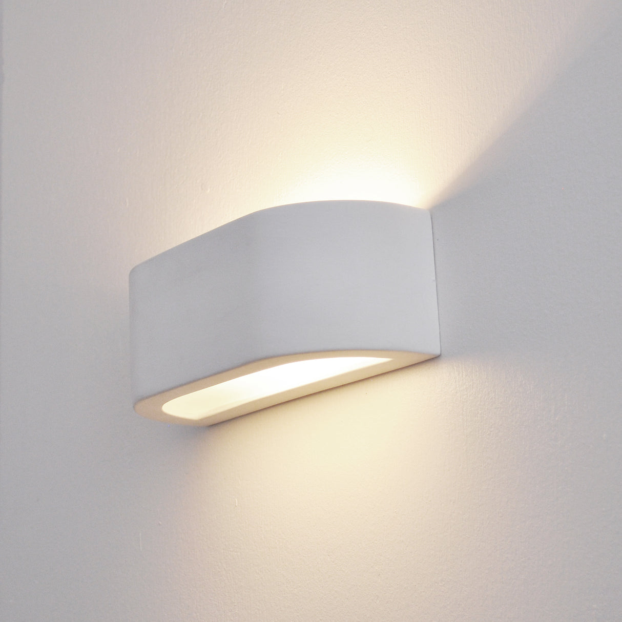 White wall-mounted LED light fixture on a plain wall