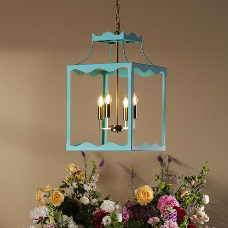 A turquoise blue hanging lantern-style chandelier with lit candle bulbs is suspended above a round table decorated with a large floral arrangement in pink, white, yellow, and burgundy flowers against a warm beige wall.