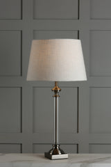 Modern table lamp with white fabric shade and clear acrylic base on marble surface