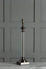 Modern metallic table lamp base with clear cylindrical body on marble surface