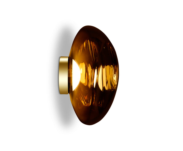 Modern amber glass LED wall light with gold base against white background