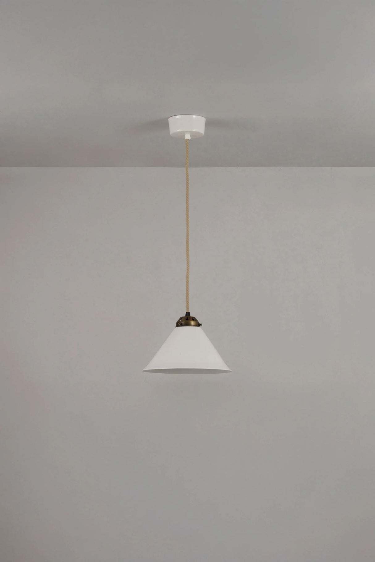 Original BTC Cobb. Pendant light fixture hanging from a ceiling on a plain wall.