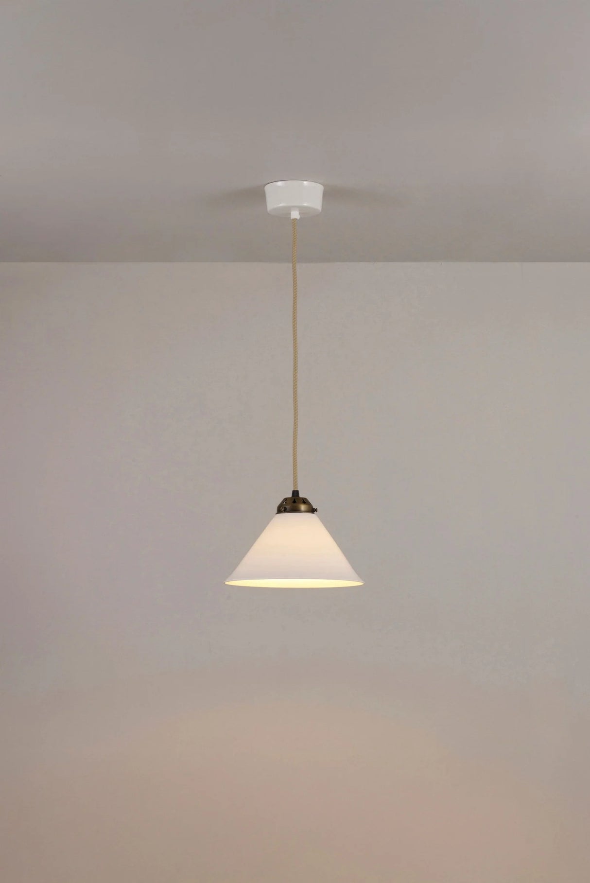 Original BTC Cobb Small. Pendant light fixture hanging from a ceiling against a plain wall.
