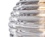 Close-up of a clear ribbed glass pendant light with warm 2700K LED glow
