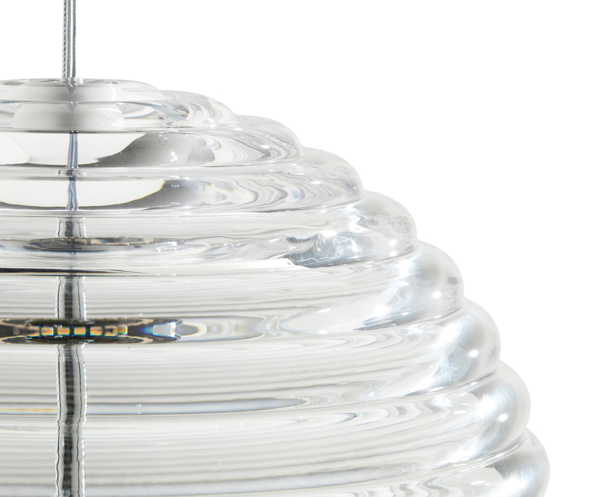 Close-up of a clear glass pendant light with concentric circular ridges and an LED bulb inside