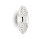 Clear glass wall sconce with concentric circular design mounted on white wall