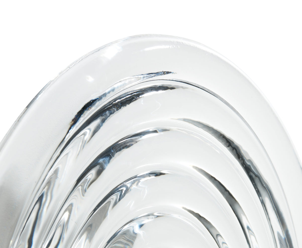 Close-up of clear glass press surface with concentric circular ridges on white background
