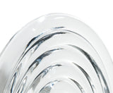 Close-up of clear glass press surface with concentric circular ridges on white background